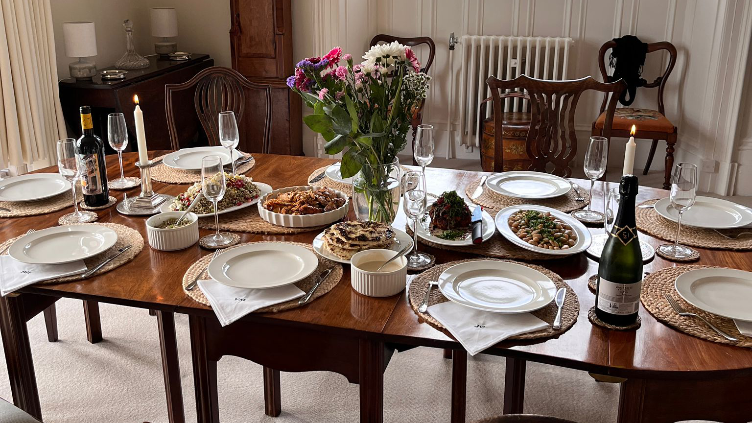 A dinner table laid out with dishes for sharing